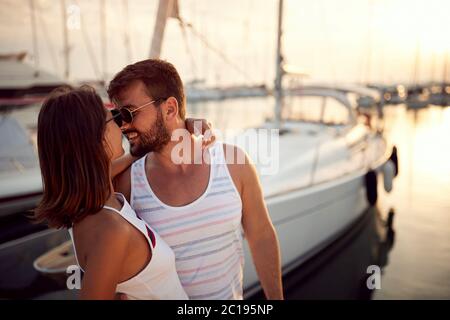 Couple appréciant au bord de la mer.Happy woman embrassant l'homme sur le quai pendant le coucher du soleil. Banque D'Images