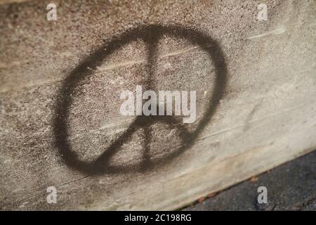 Symbole de la campagne pour le désarmement nucléaire également connu sous le nom de symbole de la paix graffiti sur un mur de béton Banque D'Images