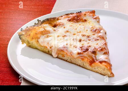 Une tranche de pizza traditionnelle italienne Margherita sur une assiette recouverte de tomates et de mozzarella fondue, dans une vue rapprochée en grand angle Banque D'Images
