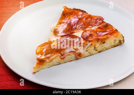 Tranche de garnitures traditionnelles italiennes épicées de salami sur une assiette blanche générique en gros plan montrant la texture de la base Banque D'Images