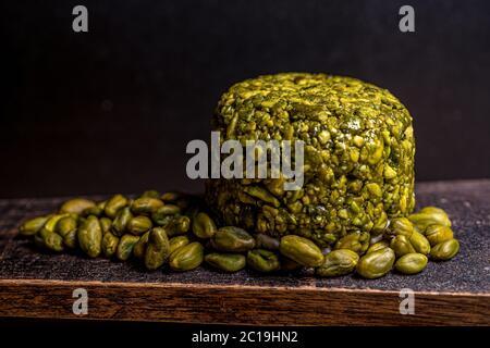 Boules de fromage de chèvre enveloppées de pistache. Fromage sur fond noir. Dîner traditionnel. Photo de haute qualité Banque D'Images