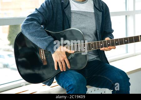 Le guitariste joue de la guitare. Ou une personne apprend à jouer de la guitare. Banque D'Images