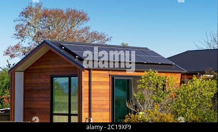 Vivant hors de la grille. Des panneaux solaires produisent de l'électricité d'une maison hors réseau en Nouvelle Zélande. Banque D'Images