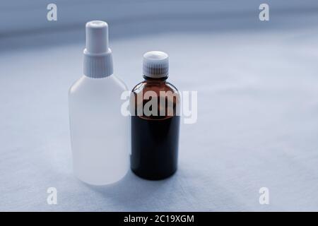 bouteille marron et blanche sur un fond en tissu léger. Flacon de solvant pharmaceutique ou chimique en verre ambré avec bouchon Banque D'Images