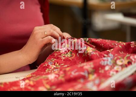 tailleur femme ragoûts robe rouge. Travailler sur mesure dans son atelier de travail sur mesure Banque D'Images