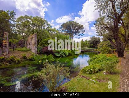 Jardin de Ninfa (Latina, Italie) - UN monument naturel privé avec des ruines médiévales en pierre, parc de fleurs et un torrent impressionnant avec peu de chute. Banque D'Images