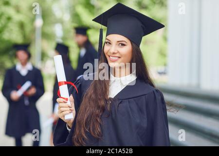 Une jeune femme diplômée dans le contexte des diplômés universitaires. Banque D'Images