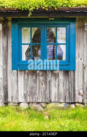 Ancienne ferme en bois typique avec fenêtre bleue et toit en herbe en Suède Banque D'Images