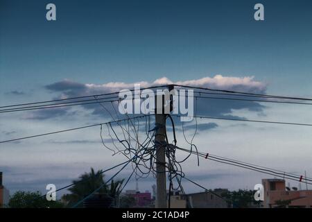poteau électrique bleu avec fils de fond nuages avec arbres verts Banque D'Images