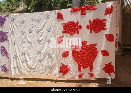 Nappe en tissu à vendre sur le trottoir, village d'Ampangorinana, île de Nosy Komba, Madagascar. Banque D'Images