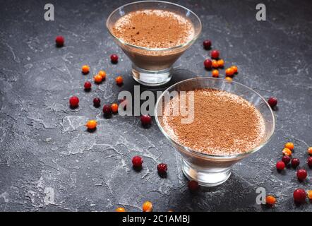 Deux verres de mousse au chocolat-fromage avec baies sur fond de pierre sombre Banque D'Images