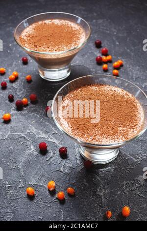 Deux verres de mousse au chocolat-fromage avec baies sur fond de pierre sombre Banque D'Images