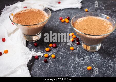 Deux verres de mousse au chocolat-fromage avec baies sur fond de pierre sombre Banque D'Images