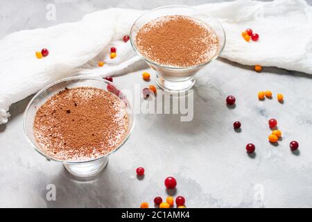 Deux verres de mousse au chocolat-fromage avec baies sur fond de béton Banque D'Images