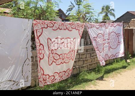 Nappes à vendre suspendues à la vente sur trottoir, Village d'Ampangorinana, île de Nosy Komba, Madagascar. Banque D'Images