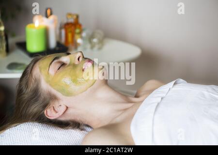 Belle femme détendue ayant le masque de visage d'argile Banque D'Images