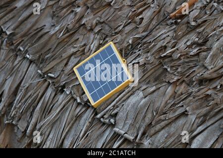 Panneau solaire sur le toit traditionnel en chaume de palmier, village d'Ampangorinana, île de Nosy Komba, Madagascar. Banque D'Images