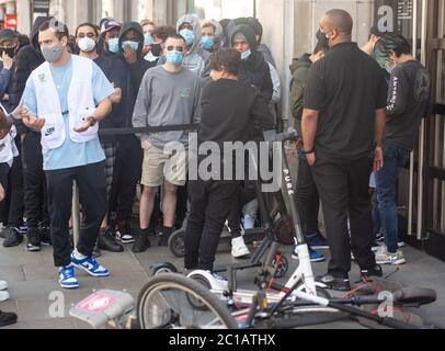 Les gens font la queue devant Nike Town à Oxford Circus, Londres, alors que les magasins non essentiels en Angleterre ouvrent leurs portes aux clients pour la première fois depuis que les restrictions de verrouillage du coronavirus ont été imposées en mars. Banque D'Images