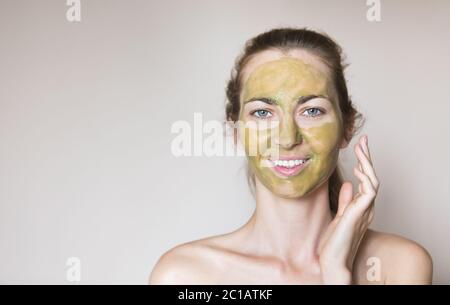 Belle femme détendue ayant un masque de visage en argile verte Banque D'Images