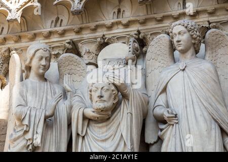 Détails architecturaux de la cathédrale notre Dame de Paris sur l'île de la Cité à Paris Saint Denis tenant sa tête Banque D'Images