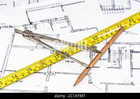 Compas et crayon reposant sur le plan de construction Banque D'Images