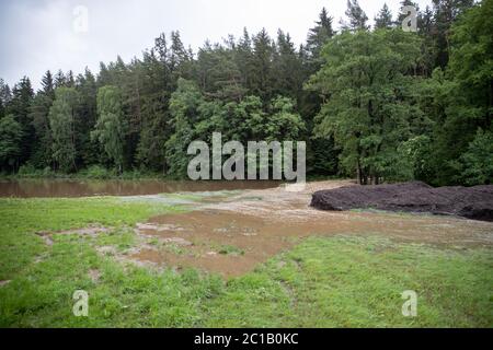 Oberbibrach, Allemagne. 15 juin 2020. L'eau coule par le passage brisé d'un étang voisin dans le district de la municipalité du Haut-Palatinat de Vorbach (district de Neustadt an der Waldnaab). Le ruisseau d'Oberbibrach s'est développé en un ruisseau torrentiel après que le barrage a éclaté la nuit et a partiellement inondé le district. Crédit : Daniel Karmann/dpa/Alay Live News Banque D'Images