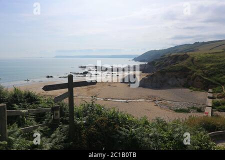 Une plage par jour nuageux à Cornwall avec une pancarte en premier plan. Banque D'Images