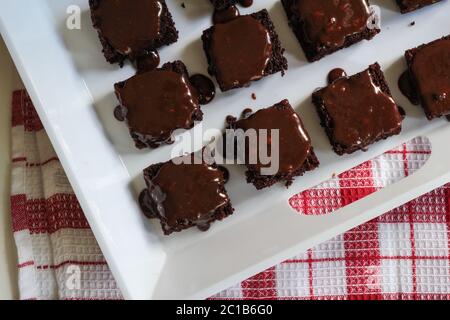 Brownies au chocolat recouvertes de ganache aux noix de chocolat - vue rapprochée des carrés de brownie en merde Banque D'Images