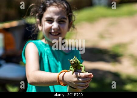 Petite fille avec une caméléon sur ses mains. Concentrez-vous sur l'animal Banque D'Images