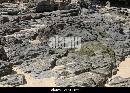 Rochers volcaniques sur la plage, village d'Ampangorinana, île de Nosy Komba, Madagascar. Banque D'Images