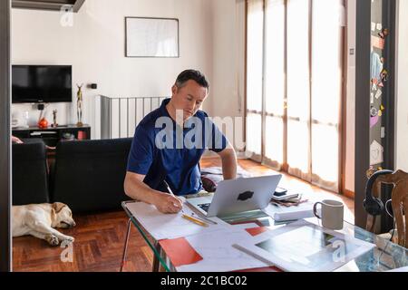 Homme travaillant de chez lui pendant le verrouillage du virus Corona lors d'une réunion en ligne. Banque D'Images