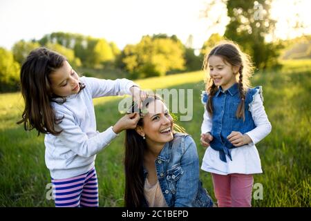 Mère avec deux petites filles ayant l'amusement à l'extérieur dans la nature de printemps. Banque D'Images