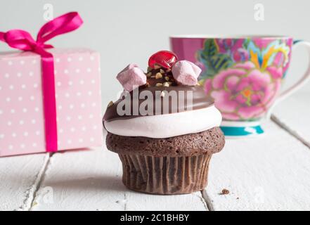 Cup Cake anniversaire célébration Contexte - cupcake chocolat avec boîte cadeau rose et verre Banque D'Images