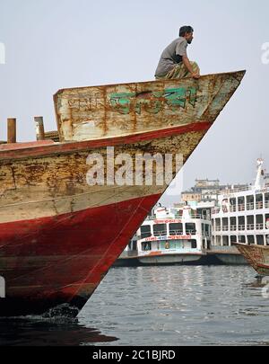 Sadarghat à Dhaka, au Bangladesh. Un homme local assis sur l'arc d'un grand navire à Sadarghat, Dhaka. Banque D'Images