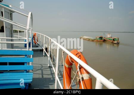 La rivière Pashur près de Mongla au Bangladesh. Vue depuis un bateau allant de la forêt de Sundarban à Khulna. Près du bateau dans la zone de mise au point, loin bateau hors de la zone de mise au point. Banque D'Images