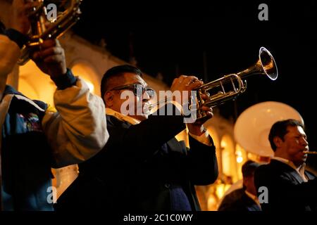 L'homme de l'orchestre joue de la trompette pendant la parade, tandis que des marches se font à côté des autres membres de l'orchestre Banque D'Images