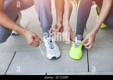 Femme et homme laçage des chaussures de course avant le travail Banque D'Images