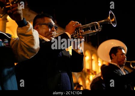 L'homme de l'orchestre joue de la trompette pendant la parade, tandis que des marches se font à côté des autres membres de l'orchestre Banque D'Images