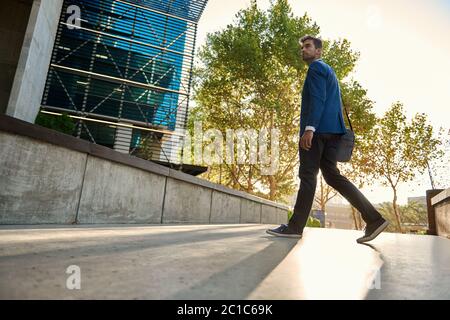 Jeune homme d'affaires élégant qui se promine dans la ville pour travailler Banque D'Images