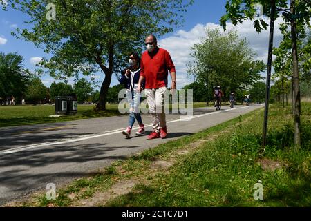 Verdun, CA - 14 juin 2020 : couple avec masques pour la protection contre la marche de COVID-19 dans un parc Banque D'Images