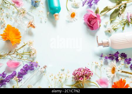 Arrangement de cosmétiques avec des bouteilles de parfum et des fleurs Banque D'Images