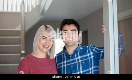 Portrait Of Smiling Young Couple ouverture porte avant de Nouvelle Maison Banque D'Images