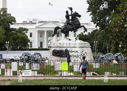 Washington, États-Unis. 15 juin 2020. Un jogger s'arrête pour regarder le graffiti d'une croix gammée sur l'état d'Andrew Jackson à Lafayette Park, près de la Maison Blanche, à Washington, DC, le lundi 15 juin 2020. La statue a été vandalisée pendant la nuit avec des graffitis représentant un signe de la swastika nazie et les mots, « Hiroshima Nagasaki ». Lafayette Park a récemment été rouvert à la suite de manifestations contre la mort de George Floyd alors qu'il était en garde à vue à Minneapolis. Photo de Kevin Dietsch/UPI crédit: UPI/Alay Live News Banque D'Images