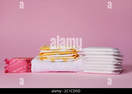 différents tampons de coton hygiéniques menstruels sur fond rose. Produits d'hygiène féminine. Espace de copie. Banque D'Images