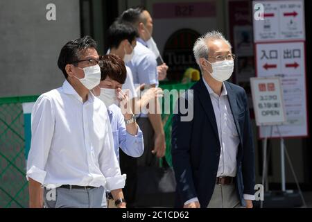 Tokyo, Japon. 15 juin 2020. Les piétons portant des masques faciaux marchent sous la chaleur dans la zone commerçante de Ginza. Les températures ont augmenté de plus de 30 degrés Celsius dans de nombreuses régions du Japon lundi. Les gens continuent à utiliser le masque facial en raison de la pandémie du coronavirus. Credit: Rodrigo Reyes Marin/ZUMA Wire/Alay Live News Banque D'Images