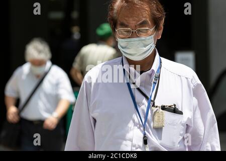 Tokyo, Japon. 15 juin 2020. Les piétons portant des masques faciaux marchent sous la chaleur dans la zone commerçante de Ginza. Les températures ont augmenté de plus de 30 degrés Celsius dans de nombreuses régions du Japon lundi. Les gens continuent à utiliser le masque facial en raison de la pandémie du coronavirus. Credit: Rodrigo Reyes Marin/ZUMA Wire/Alay Live News Banque D'Images