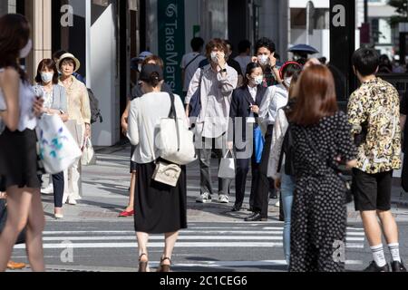 Tokyo, Japon. 15 juin 2020. Les piétons portant des masques faciaux marchent sous la chaleur dans la zone commerçante de Ginza. Les températures ont augmenté de plus de 30 degrés Celsius dans de nombreuses régions du Japon lundi. Les gens continuent à utiliser le masque facial en raison de la pandémie du coronavirus. Credit: Rodrigo Reyes Marin/ZUMA Wire/Alay Live News Banque D'Images