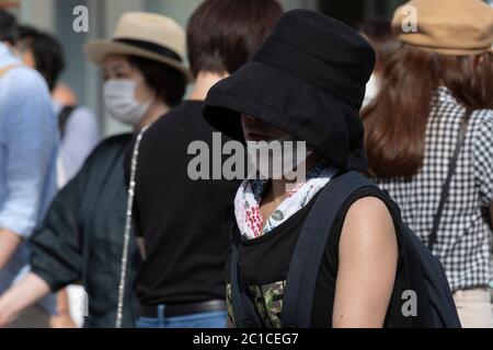 Tokyo, Japon. 15 juin 2020. Les piétons portant des masques faciaux marchent sous la chaleur dans la zone commerçante de Ginza. Les températures ont augmenté de plus de 30 degrés Celsius dans de nombreuses régions du Japon lundi. Les gens continuent à utiliser le masque facial en raison de la pandémie du coronavirus. Credit: Rodrigo Reyes Marin/ZUMA Wire/Alay Live News Banque D'Images