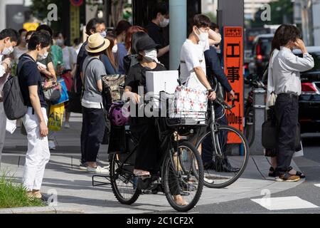 Tokyo, Japon. 15 juin 2020. Les piétons portant des masques sont vus sous la chaleur dans la zone commerçante de Ginza. Les températures ont augmenté de plus de 30 degrés Celsius dans de nombreuses régions du Japon lundi. Les gens continuent à utiliser le masque facial en raison de la pandémie du coronavirus. Credit: Rodrigo Reyes Marin/ZUMA Wire/Alay Live News Banque D'Images