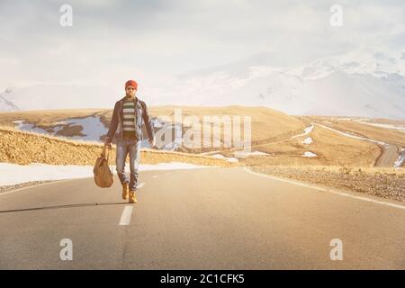 Un élégant boxeur à dos rétro et à dos de soleil fait une promenade sur la route asphaltée par une journée ensoleillée. Le concept de hitc Banque D'Images